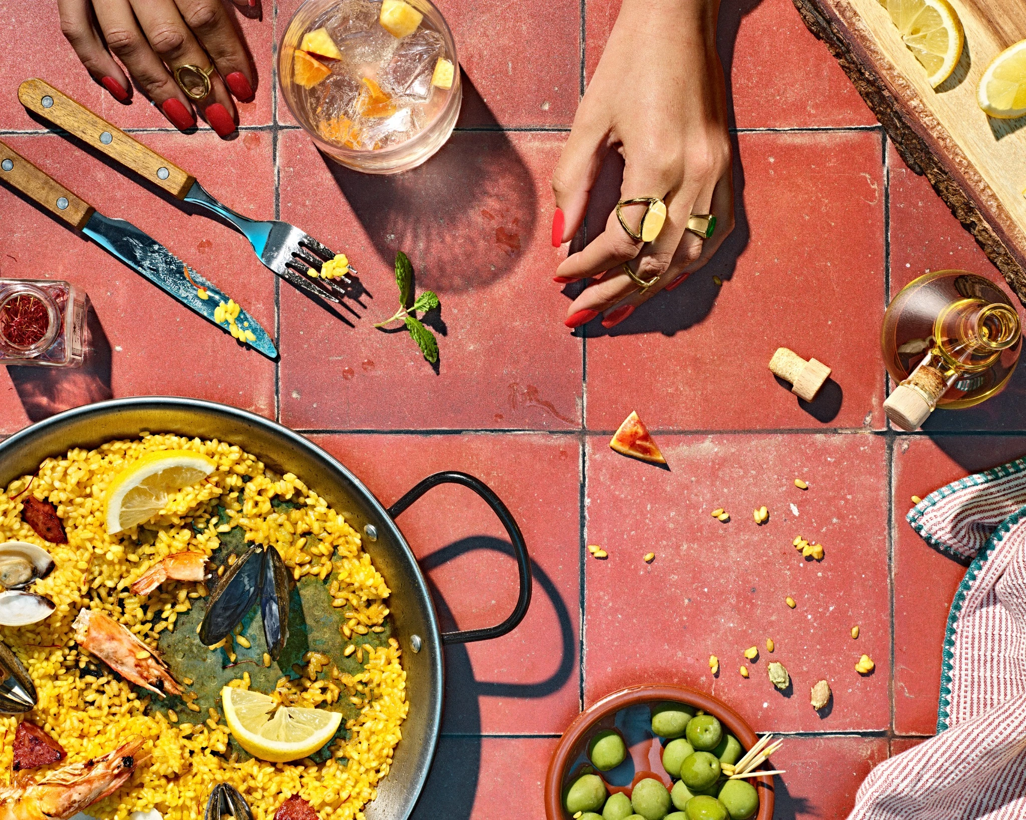 Overhead paella table after eating with olives and drinks